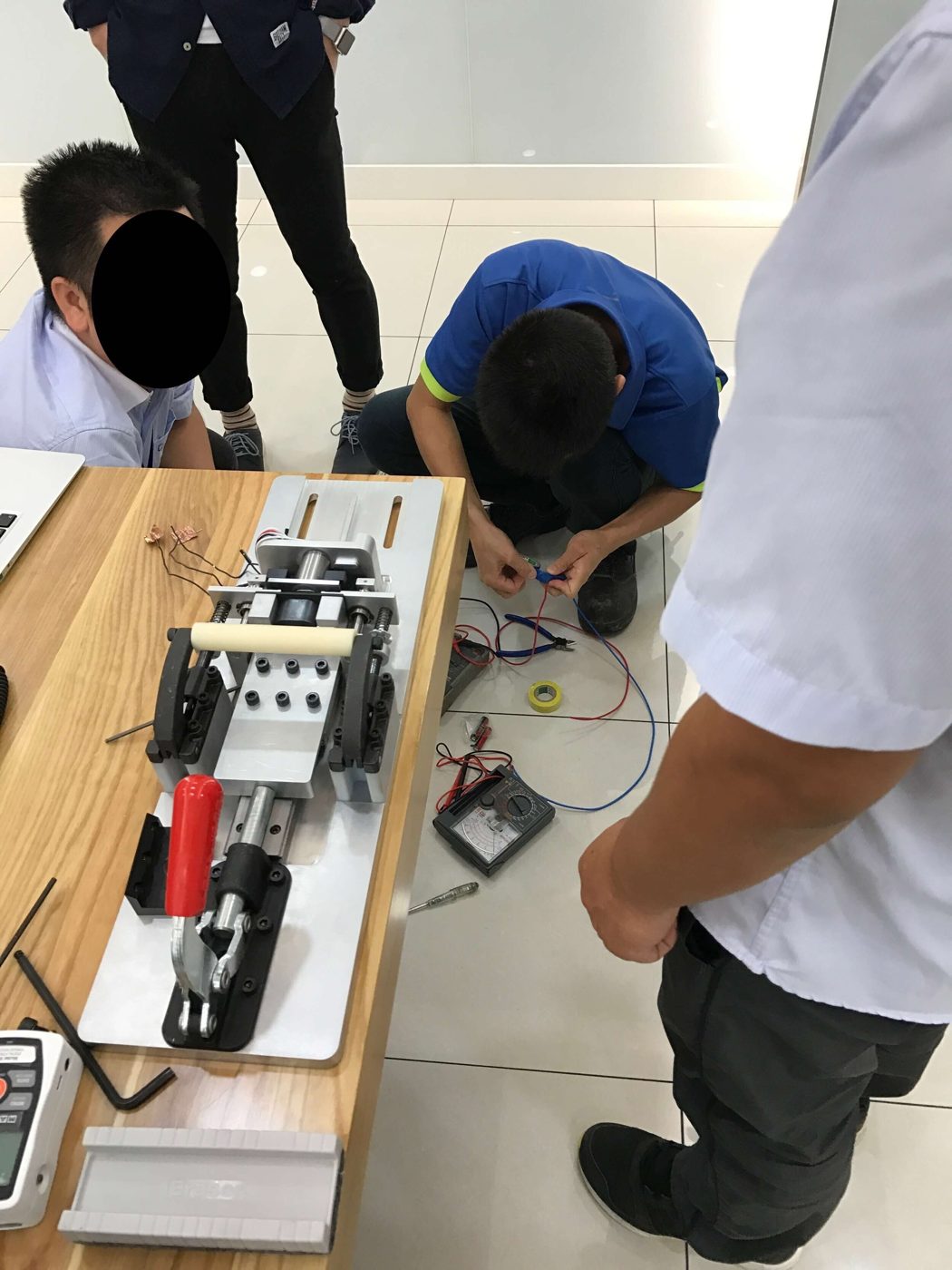 Vendor technicians assembling a copy of the bolt test fixture on a workbench