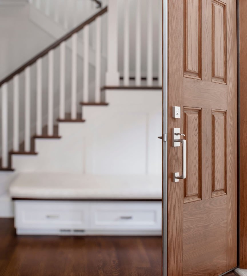 An open wood entry door with Tyto's metal edge and a satin nickel handleset